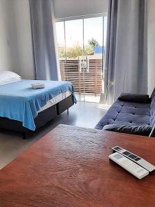 una camera con letto, divano e tavolo di Pousada Suítes do Rosa a Praia do Rosa