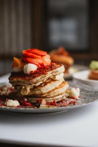a stack of pancakes with fruit on a plate at The Harvest Hotel in Cromwell