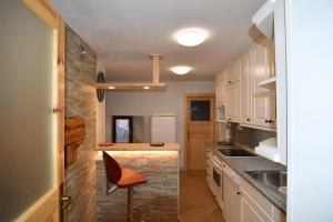 a kitchen with white cabinets and a red chair in it at Apartment Perunika in Cerkno