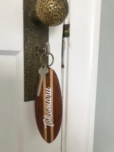 a wooden keychain hanging on a door at Cedar House in Gisborne