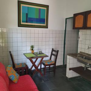 Habitación con mesa, sillas y lavabo. en Suíte 1, aconchegante, privativa e independente, en Cuiabá