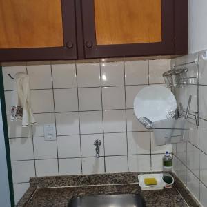 cocina con fregadero y pared de azulejos en Suíte 1, aconchegante, privativa e independente en Cuiabá