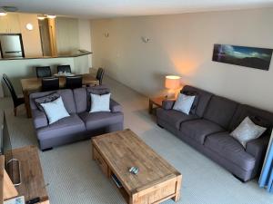 a living room with two couches and a coffee table at Sea Point Ocean Apartments in Caloundra