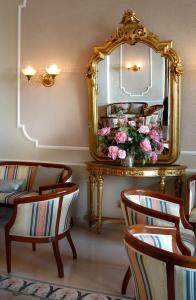 a room with two chairs and a mirror and flowers at Hotel Vittoria in Premeno +25 photos