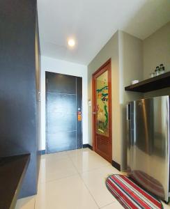 a hallway with a refrigerator and a door in a house at B Space Residence in Nong Prue