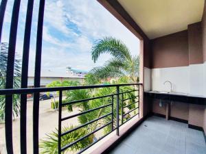 a balcony with a view of a palm tree at B Space Residence in Nong Prue