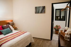 a bedroom with a bed and a door with a window at casa VOLCAN x Santiago de tequila in Tequila