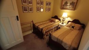 a bedroom with two beds and a teddy bear on the bed at Blakes Manor Self Contained Heritage Accommodation in Deloraine