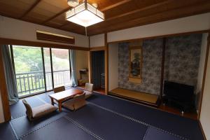 箱根町にあるOnsen & Garden -Asante Inn-のテーブルとテレビのあるリビングルーム