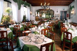 a dining room with tables with green tablecloths at Hotel Vittoria in Premeno