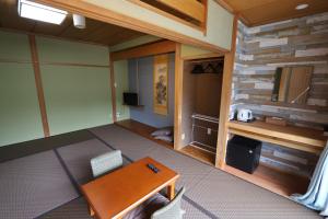 箱根町にあるOnsen & Garden -Asante Inn-のテーブルとデスクが備わる空き部屋