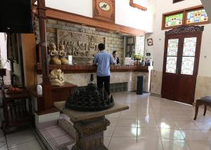 Ein Mann steht an einem Tresen in einem Laden. in der Unterkunft Hotel Mataram Malioboro in Yogyakarta