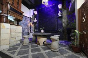 um quarto com uma mesa e uma parede roxa em Hotel Mataram Malioboro em Yogyakarta
