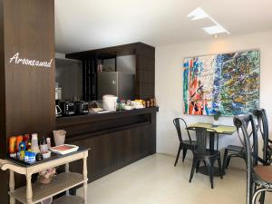 a kitchen with a counter and a table with chairs at Homey Dormy Chiangrai in Chiang Rai