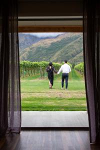 
two people standing in front of a large screen tv at Kinross Boutique Vineyard Hotel in Gibbston
