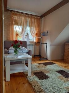 uma sala de estar com um sofá e uma mesa em Gospodarstwo agroturystyczne Biebrzanska Goscina em Karcewo