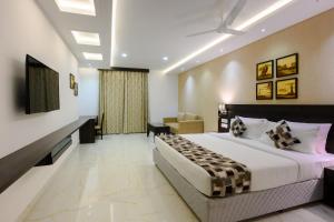 um quarto com uma cama grande num quarto em Essentia Manipal Inn em Udupi
