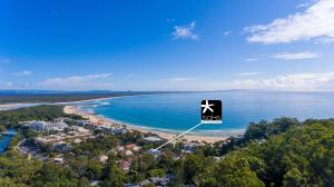 a sign flying over a beach next to the ocean at Saks on Hastings in Noosa Heads