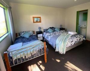 a bedroom with two beds and a window at White Elephant Accomodation in Motueka
