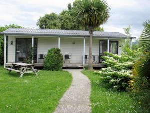 a white house with a picnic table in the yard at White Elephant Accomodation in Motueka