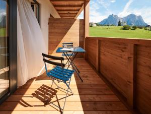 Un balcón con una silla azul y una mesa en Alpe di Susi en Castelrotto
