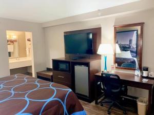 a hotel room with a bed and a desk with a desk at Super 8 by Wyndham Cookeville, TN in Cookeville