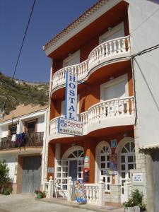 un edificio con una señal azul en el costado. en Hostal D´Ernes en Alcalá del Júcar