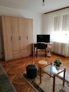un soggiorno con tavolo e scrivania di Apartman KIKA a Sombor