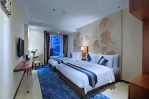 una camera d'albergo con un grande letto e una TV di Aston Inn Gideon Batam a Nagoya