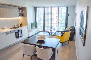 een keuken en een woonkamer met een tafel en stoelen bij AirTrip Apartments on Tribune Street in Brisbane