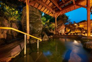 una piscina d'acqua in un resort con cascata di Awazuonsen Kitahachi a Komatsu
