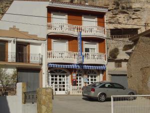 un edificio con un coche aparcado delante de él en Hostal D´Ernes en Alcalá del Júcar