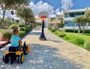 a child riding a toy car on a street at Made of Blue luxury suites collection in Rethymno
