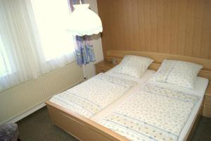 two twin beds in a room with a window at Gästehaus Wetzel in Braunlage