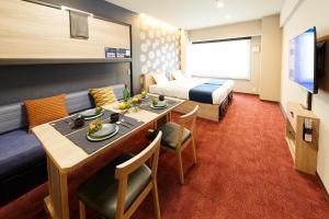 een hotelkamer met een eettafel en een bed bij MONday Apart 日本橋水天宮前 in Tokyo