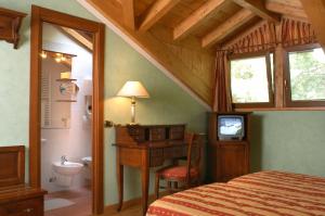 a bedroom with a bed and a desk and a television at Hotel Vittoria in Premeno