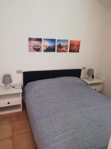 バデージにあるIl Geranioのベッドルーム1室(壁に3枚の写真が飾られたベッド1台付)