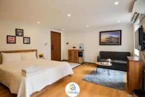 ハノイにある22Housing luxury Hotel & Residence 39 Linh Langのベッドルーム(ベッド1台、ソファ、テレビ付)