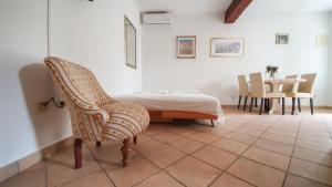 a bedroom with a bed and a chair and a table at Apartments Obala in Bol