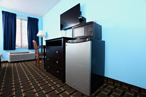 a hotel room with a refrigerator and a blue wall at Coratel Inn & Suites by Jasper Newton in Newton