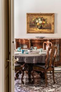 a dining room with a table and a painting at Spa sul tempio d'apollo in Syracuse