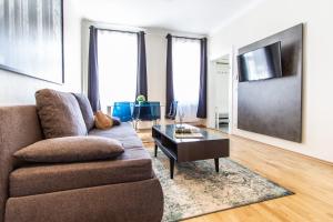 uma sala de estar com um sofá e uma mesa de centro em Apartment Landgutgasse em Viena