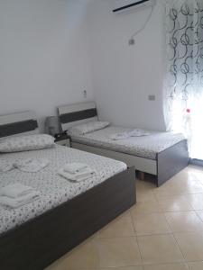 a room with two beds with towels on them at Apartamente-Danaj Radhime in Vlorë