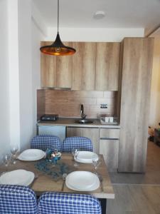 - une cuisine avec une table, des chaises et un évier dans l'établissement Apartman Adelfes P16, Milmari Resort, à Kopaonik