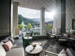 a living room with a couch and a large window at InterContinental Phuket Resort by IHG in Kamala Beach