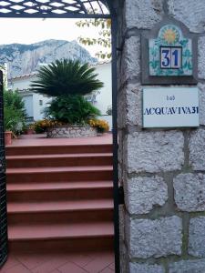 un cartel en una pared al lado de unas escaleras en Acquaviva 31, en Capri