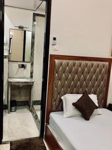 a bedroom with a bed with a mirror next to it at Shree Ganesha Palace in Varanasi