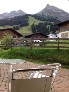 a table and chair on a patio with mountains in the background at 2-Zimmer Ferienwohnung,Parterre,Sitzplatz,Garage in Adelboden