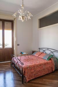 a bedroom with a bed and a chandelier at Spa sul tempio d'apollo in Syracuse