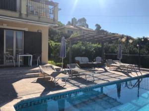 a group of chairs and umbrellas next to a pool at Villino Lenci in Trappitello